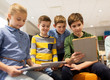 © Syda Productions - group of happy children with tablet pc at school