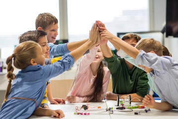 Wall Mural - happy children making high five at robotics school