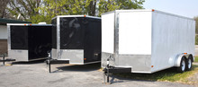 Three Black And White Transport Trailers In A Row.
