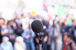 © wellphoto - Microphone in focus, against blurred crowd