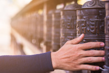 Abstract Background Of Hand Rolling Prayer Wheels With Lens Flare, Buddhist Belief