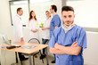 © W PRODUCTION - portrait of a young male surgeon residential student in hospital office wearing a operating room outfit