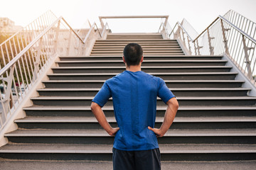 Wall Mural - Young athletic runner preparing to run up steep stairs