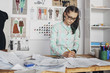 © fStop - Beautiful fashion designer drawing sketch at workbench in studio