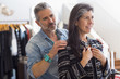 © Marc Romanelli/Blend Images - Man helping woman with jacket in store