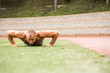 © Adam Hester/Blend Images - Caucasian man doing push-ups on sports field