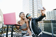 © Peathegee Inc/Blend Images - Black DJ and man posing for cell phone selfie on urban rooftop