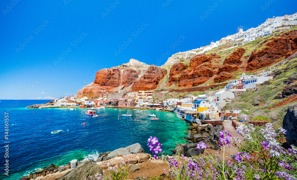 The old harbor of Ammoudi under the famous village of Ia at Santorini, Greece. - obrazy, fototapety, plakaty 