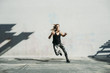 © Cavan Images - Dedicated female athlete exercising on sidewalk against white wall
