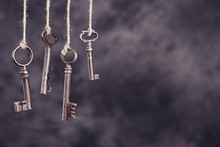 Four Old Rusty Keys Hanging On Dark Abstract Background With Copy Space. Security Concept