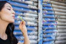 Thai Woman Blowing Bubbles In City