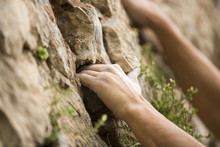 Rock Climber's Hand Grasping Handhold On Natural Cliff. His Hand Is Covered In Chalk. Shallow Depth Of Field.