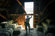 © Inti St Clair/Blend Images - Caucasian farmer resting in barn near bales of hay
