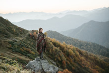 Caucasian Woman Standing On Mountain Rock Overlooking Valley