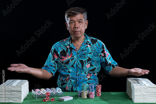 Rich man with stack of banknote and chips in casino плакат