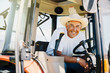 © Inti St Clair/Blend Images - Portrait of smiling Caucasian farmer in tractor