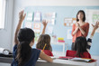 © JGI/Jamie Grill/Blend Images - Girls raising hand for teacher in classroom