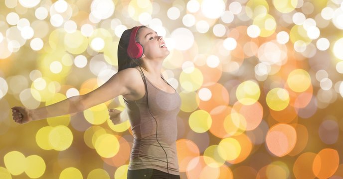 Female music artist wearing headphones over bokeh