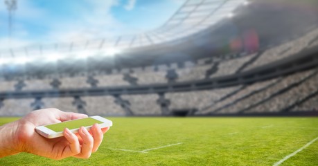 Poster - Cropped image of hand holding smart phone at stadium