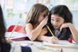 © JGI/Jamie Grill/Blend Images - Girl whispering to classmate in school