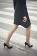 Classic retro styled woman legs portrait - She is over a crosswalk on the street - Fashion classic woman legs