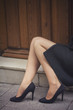 Classic retro styled woman legs portrait - She is sitting in front of a vintage door - Fashion classic woman legs