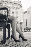 Fototapeta Konie - Classic retro styled woman legs in a city - Female woman legs, sitting, black and white fashion portrait