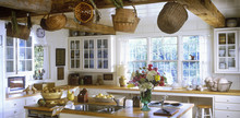 Island, Exposed Beams With Baskets, Paned Glass Cabinets, Wood Counter Tops, Looking Over The Island To Windows