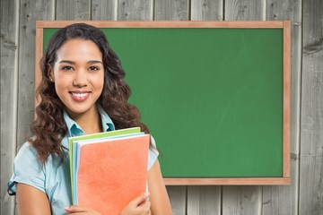Poster - Female student holding book against chalkboard