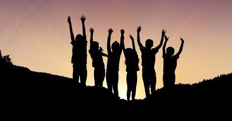 Poster - Silhouette children with hands raised on mountain during sunset