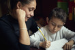 © Paco Navarro/Blend Images - Mother watching son practicing writing alphabet