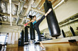 © Peathegee Inc/Blend Images - Asian woman kicking heavy bag in gymnasium