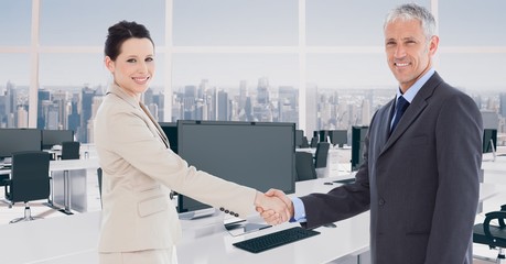 Poster - Portrait of confident business partners shaking hands in office