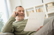 © JGI/Jamie Grill/Blend Images - Older Caucasian man talking on telephone reading paperwork