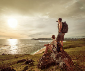 Wall Mural - Hikers with backpacks enjoying sunset on top of a mountain.