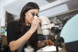 © Jasper Cole/Blend Images - Mixed Race woman using microscope