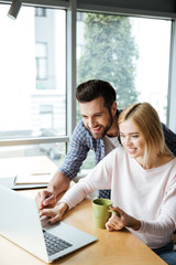 Two cheerful colleagues in office coworking