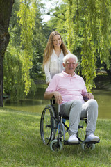 Canvas Print - Woman with elderly man on a wheelchair