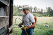© Inti St Clair/Blend Images - Caucasian farmer tying rope on fence