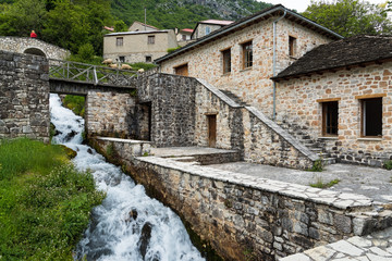 Wall Mural - Traditional stone houses and two small bridges near a small cascade in Anthochori village in Epirus, Greece