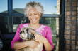 © Inti St Clair/Blend Images - Black woman hugging dog near window