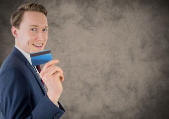 Wall Mural - Business man with credit card against brown grunge background