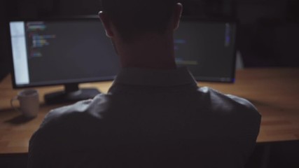 Rear view of freelancer programmer working at night