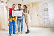 © didesign - Builder handyman shows to young couple details blueprints of their home
