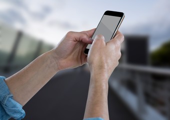 Wall Mural - Hands with phone against blurry bridge