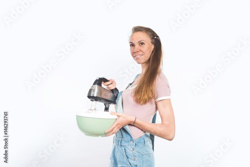 Fotografie, Obraz Young attractive smiling woman holding bowl and mixer