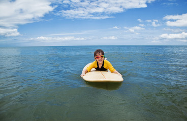 Little girl learn to surf at ocean