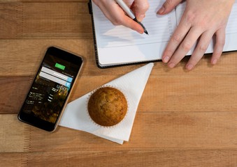 Poster - desk with phone, muffin and hands with agenda.