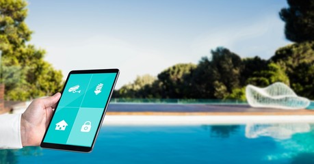 Canvas Print - Hand using smart home application on tablet PC at poolside