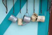 Tin Can Watering Hanging On The Color Wall. Gardening Decoration.